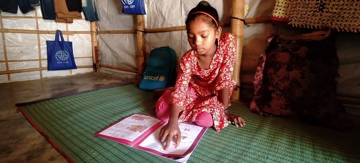 طفلة في التاسعة من عمرها تدرس في مأوى في أحد مخيمات لجوء الروهينجا في بنغلاديش. وقد أغلق مركز التعليم في المخيم بسبب كوفيد لكن والدتها ومعلمتها تشجعانها على الدراسة.