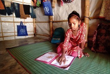 Shefuka, una niña de nueve años,  estudia en casa con el apoyo de su madre y su maestra en un campamento de refugiados Rohingya en el sur de Bangladesh. Su centro de educación del campamento está cerrado debido a la COVID-19..
