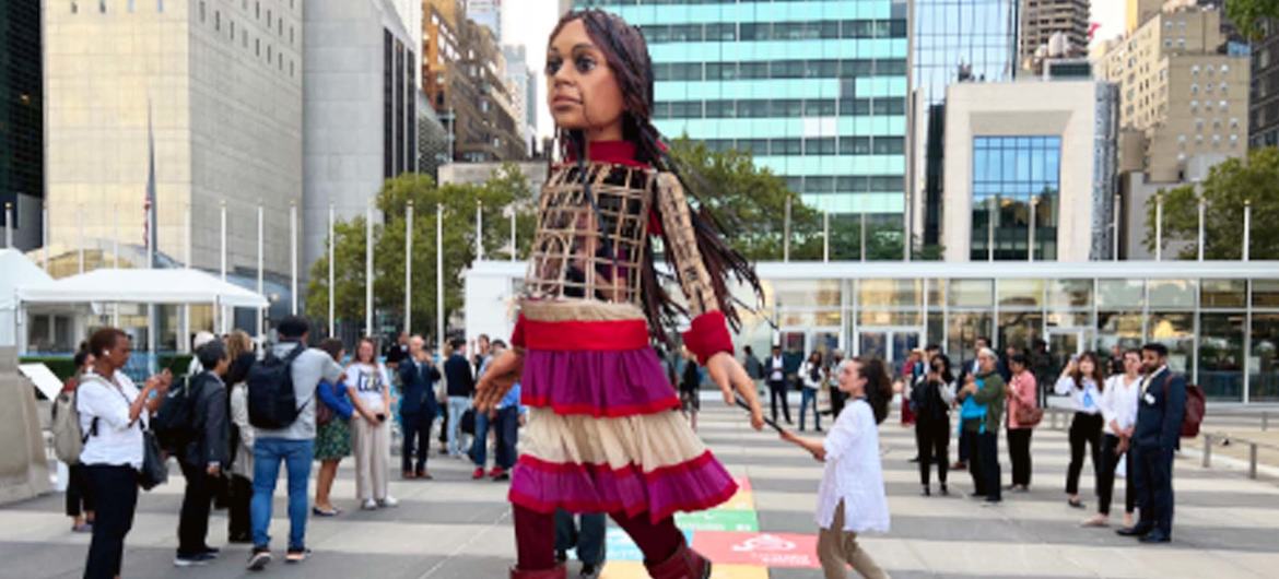 小阿迈勒，一个 12 英尺高的木偶，代表一个 10 岁的叙利亚难民，参观了在纽约联合国总部举行的教育变革峰会。她提醒人们，教育是一项基本权利。