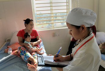 Mwanamke na mtoto wake katika hospitali ya Makara, Cambodia, wakati Nesi akipitia nyaraka zao