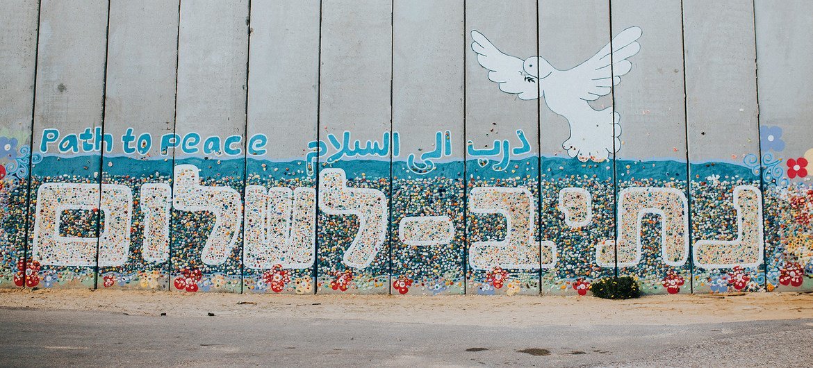 A mural on a wall in Netiv HaAsara, Israel, that faces the Gaza border and reads Path to Peace in Hebrew, Arabic, and English.