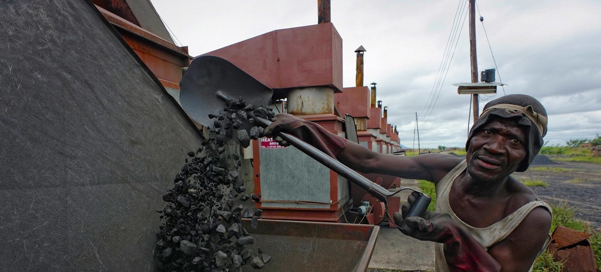 Un trabajador llena de carbón una caldera en una empresa de producción de tabaco en Malawi