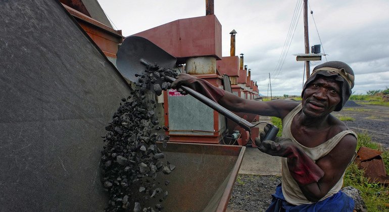 Trabalhador no Malawi enche uma caldeira com carvão em uma empresa de tabaco