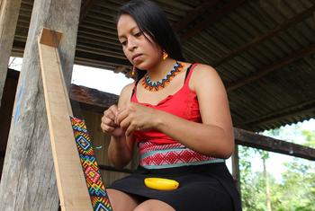 Deisy confeccionando artesanías indígenas.