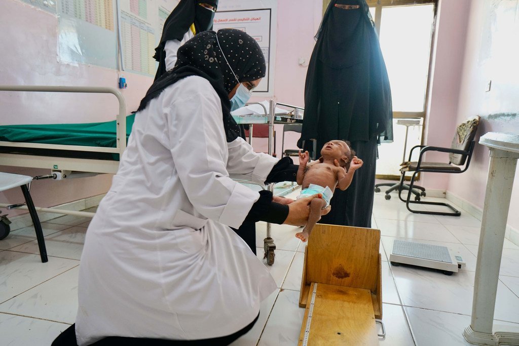 也门亚丁一家医院的一名护士对患有严重营养不良的两个月大的婴儿进行了称重和测量。