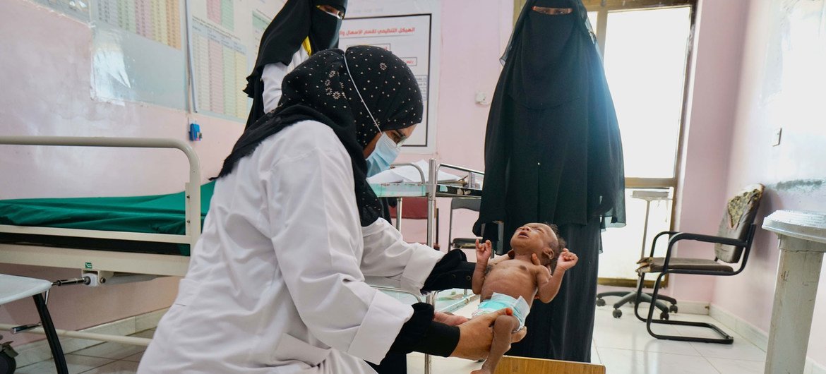 ممرضة تقوم بقياس وزن رضيع عمره شهرين يعاني من سوء التغذية الحاد في عدن باليمن.