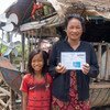 Une femme cambodgienne montre sa carte IDPoor émise par le gouvernement.