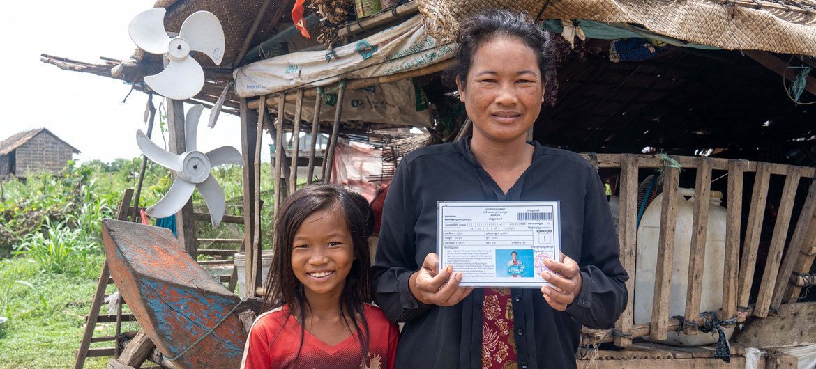 Una mujer muestra su tarjeta de transferencia de dinero emitida por el gobierno.