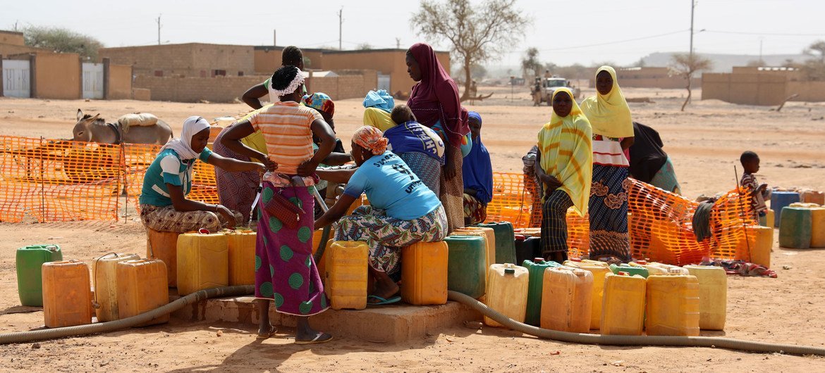 Un groupe de femmes déplacées collecte de l'eau dans la ville de Djibo au Burkina Faso.