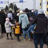 Des réfugiés en provenance d'Ukraine entrent en Pologne au poste frontière de Medyka en mars 2022.