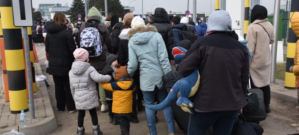 Des réfugiés en provenance d'Ukraine entrent en Pologne au poste frontière de Medyka en mars 2022.