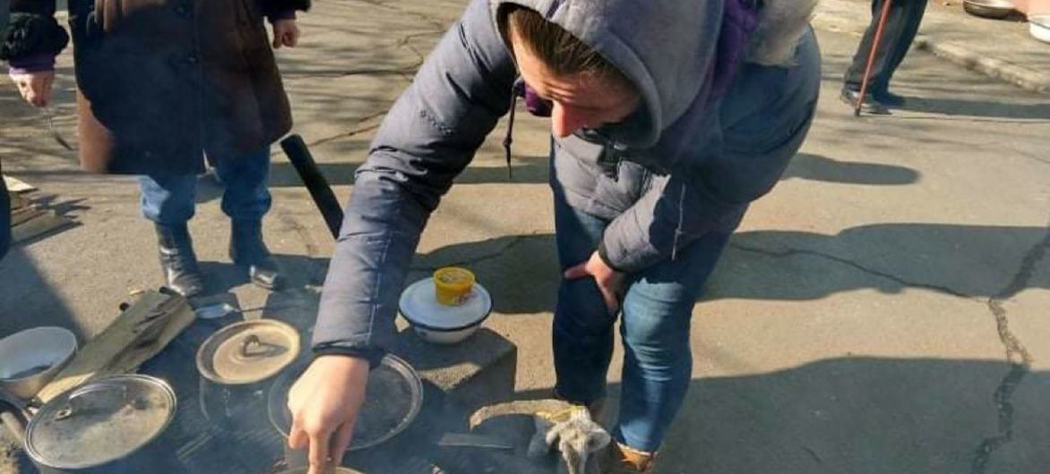 Alina Beskrovna cocina al aire libr en Mariupol tras la interrupción del suministro de gas y electricidad debido al conflicto.