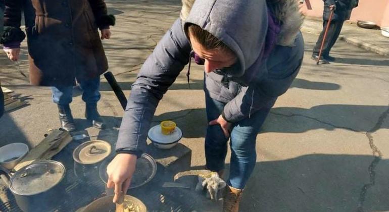 Alina Beskrovna cooks on an open fire in Mariupol after gas and electricity supplies were disrupted due to the conflict.