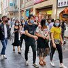新冠疫情得到控制，管制部分放开后，居民戴上口罩重回深圳罗湖东门老街。