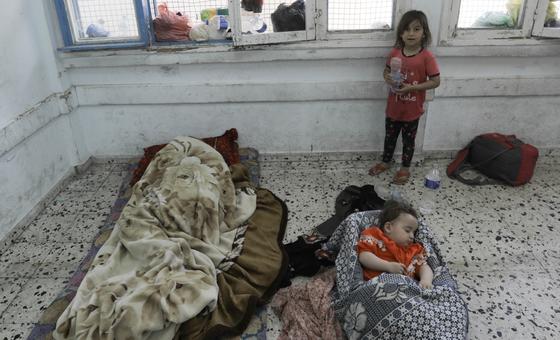 A young child watches over her toddler siblings sleeping in a classroom of UNRWA Salah Eddin School in Gaza.