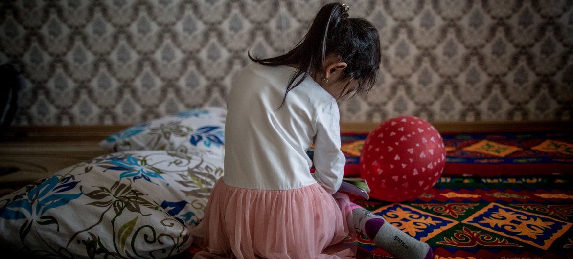 Una niña de cinco años juega en el piso de su familia en Kazajastán, donde UNICEF trabaja para eliminar la violencia doméstica contra los niños.