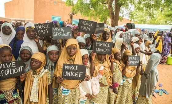 Young girls in the village of Danja in Niger hold signs in support of the Spotlight Initiative.