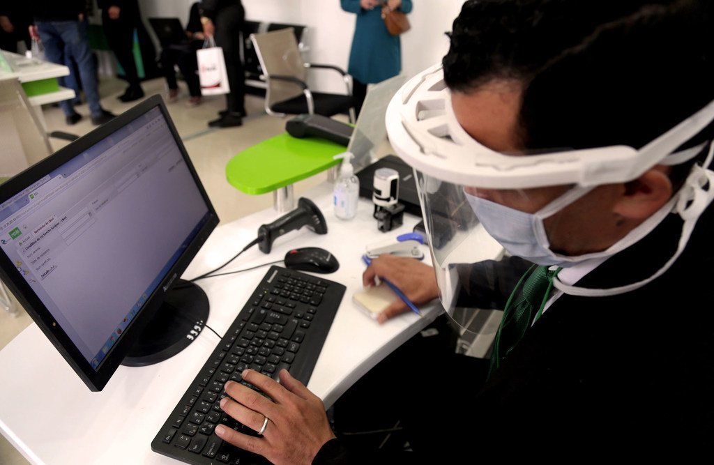 Un homme travaile à son ordinateur en Algérie en portant un masque en raison de la pandémie de Covid-19.