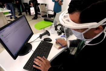 Un homme travaile à son ordinateur en Algérie en portant un masque en raison de la pandémie de Covid-19.