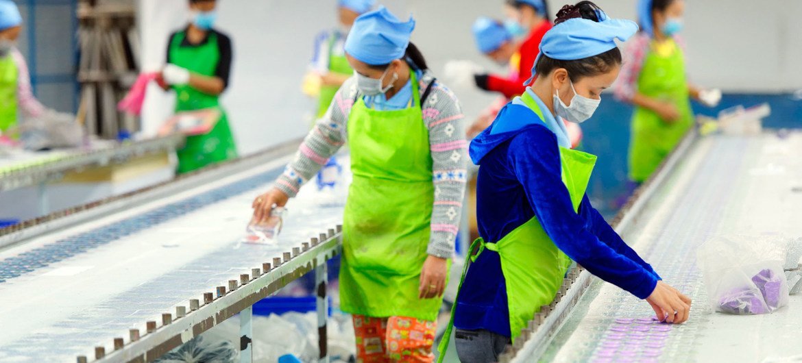 Funcionárias de fábrica no Canbodja, usando medidas de proteção individual