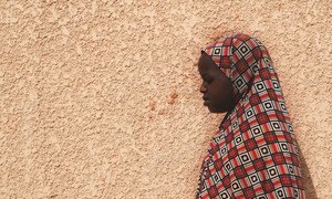 一名遭受虐待的10岁尼日尔女孩站在家门口。