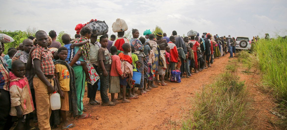 Solicitantes de asilo congoleños hacen cola para someterse a un control de seguridad y sanitario en Zombo, cerca de la frontera entre Uganda y la República Democrática del Congo.