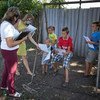 Una trabajadora social y una psicóloga reparten cuadernos para colorear a estos niños en el este de Ucrania durante una visita para conocer a la familia.