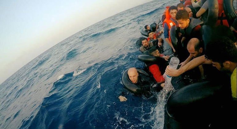 Syrian filmmaker, Hassan Akad (pictured here on the left, in the water) crossed the Mediterranean sea to seek refuge in Europe.