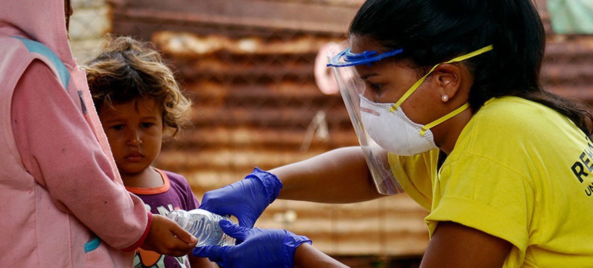 阿尔巴尼斯·奥利瓦(Albanis Oliva)是当地一家为委内瑞拉西北部一家为社区提供卫生援助的非政府组织的协调员，她在新冠病毒病大流行期间帮助幼儿进行洗手消毒。 