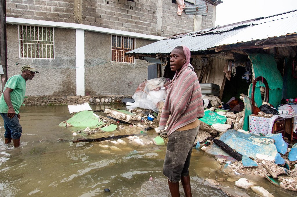 Un jeune homme se tient à l'extérieur d'une rangée de bâtiments détruits par un tremblement de terre de magnitude 7,2 en Haïti, suivi par une onde de tempête de la dépression tropicale Grace.