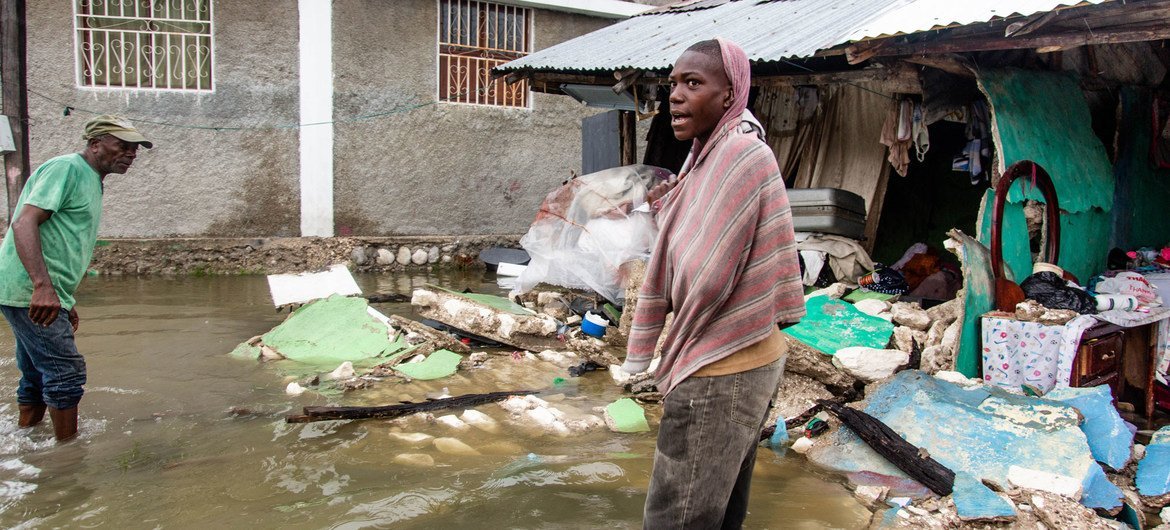 A young man stands outside a row of buildings destroyed by a 7.2 magnitude earthquake in Haiti followed by a storm surge from Tropical Depression Grace.