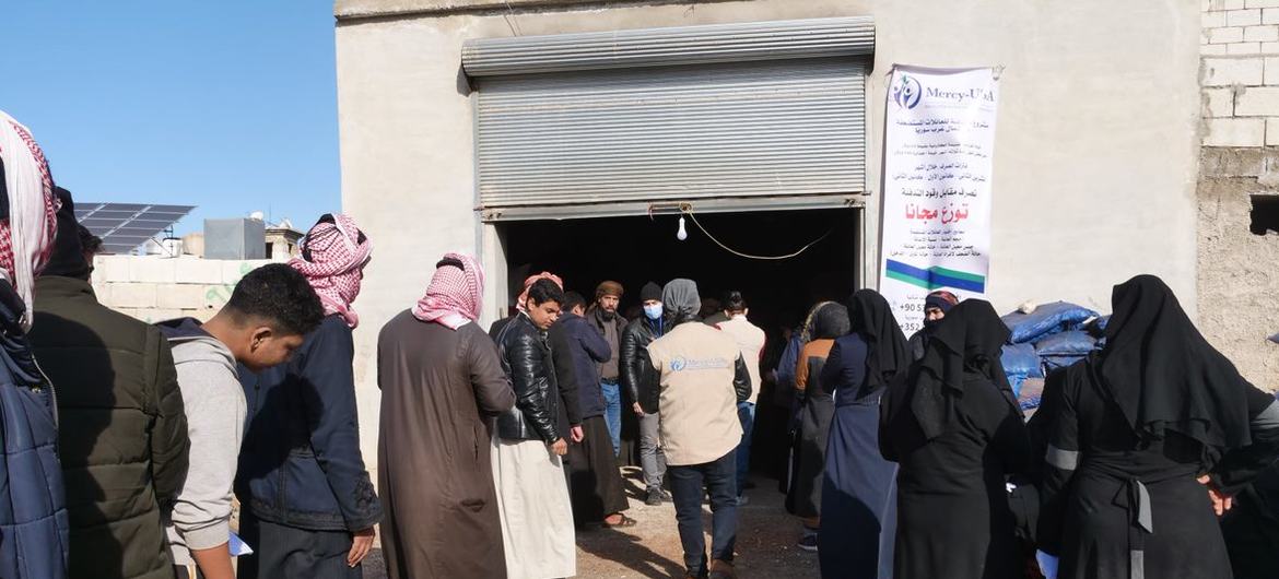 Des déplacés internes en Syrie font la queue pour recevoir de l'aide. 