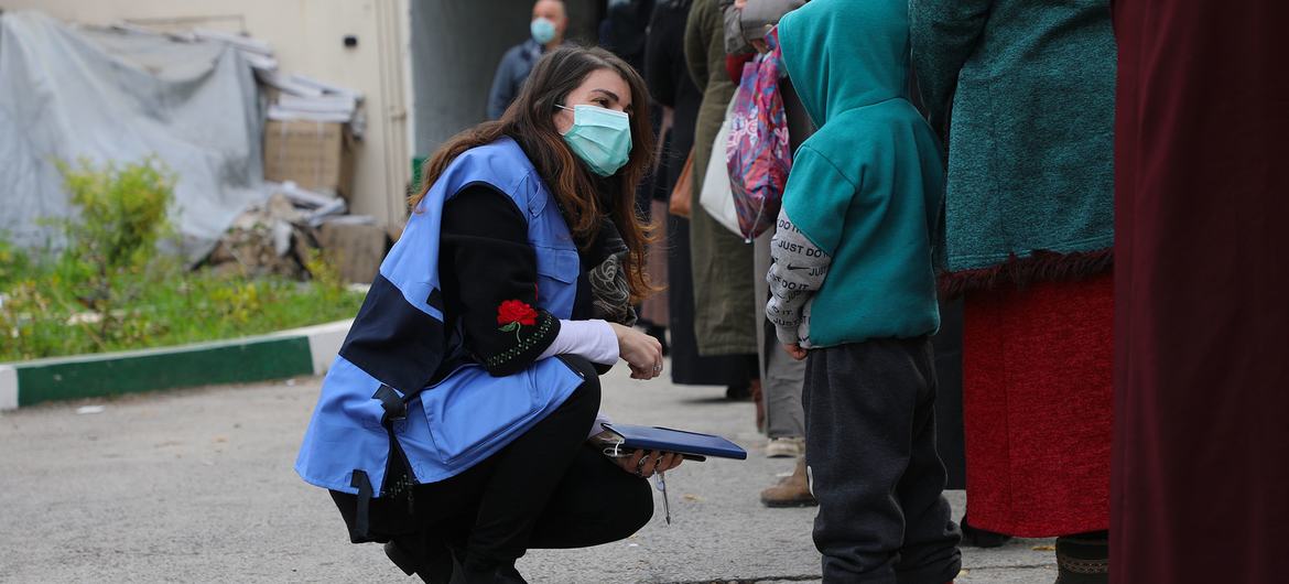 Une employée d'OCHA parle à des personnes vulnérables à Damas, en Syrie.