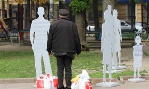 Vulnerable resident of Odessa, in Ukraine, looking at IOM counter-trafficking installation.