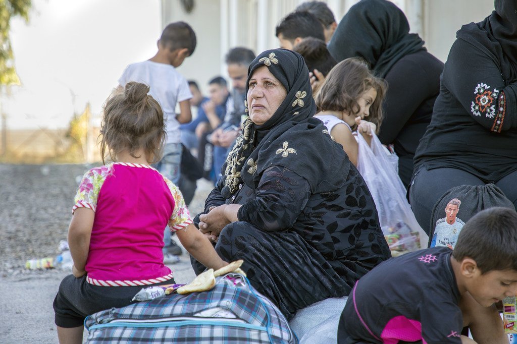 Des réfugiés syriens fuyant les combats dans le nord de la Syrie ont traversé la frontière iraquienne pour se rendre dans un centre de réception du HCR à Dohuk.