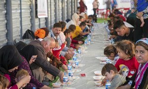 Refugees from Syria eat a hot meal supplied by UNHCR and its partners in Bardarash Camp in Iraq.