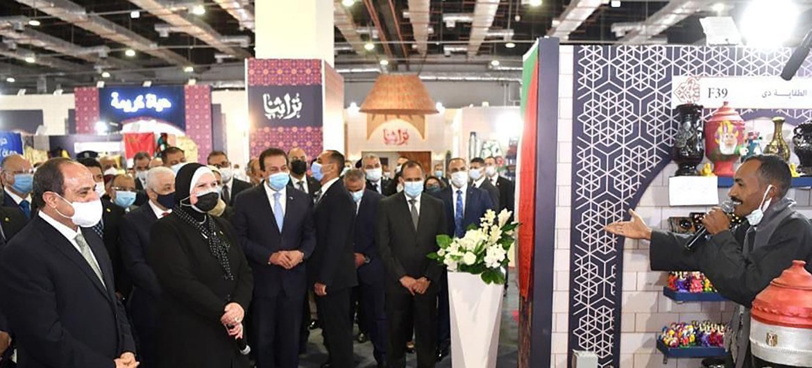 الرئيس المصري عبد الفتاح السيسي ووزيرة الصناعة نيفين جامع يستمعان لأحد العارضين.