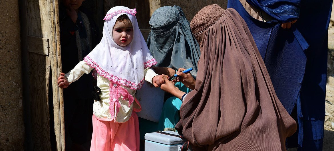 अफ़ग़ानिस्तान के दक्षिणी प्रान्त कन्दाहार में, एक बच्चे को पोलियो वैक्सीन की ख़ुराक देने की तैयारी. (फ़ाइल फ़ोटो)