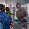 لوح بلاستيكي يفصل بين أم وابنها في مركز لعلاج الإيبولا في بني، بإقليم كيفو الشمالي، بجمهورية الكونغو الديمقراطية.