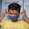 Un niño de 11 años en India muestra cómo ponerse correctamente una máscara para protegerse del COVID-19.