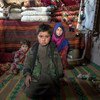 Three siblings sit inside their home in an internally displaced camp on the outskirts of the western city of Herat, Afghanistan.