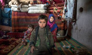 Trois frères et sœurs assis à l'intérieur de leur maison dans un camp pour personnes déplacées à l'intérieur du pays, dans la banlieue ouest de la ville de Herat, en Afghanistan.    