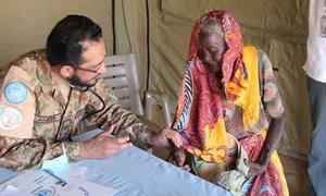 Un Casque bleu pakistanais apporte des soins médicaux à une femme dans le camp de déplacés de Khor Omer dans l'Est-Darfour.