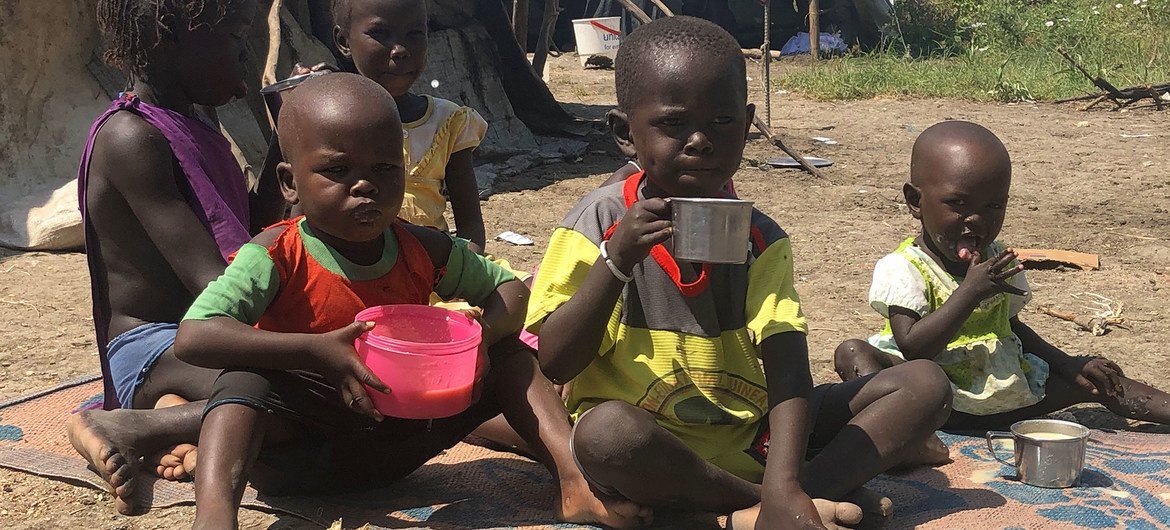 在南苏丹皮博尔的孩子们吃着母亲用世界粮食计划署派发的食物煮的粥。