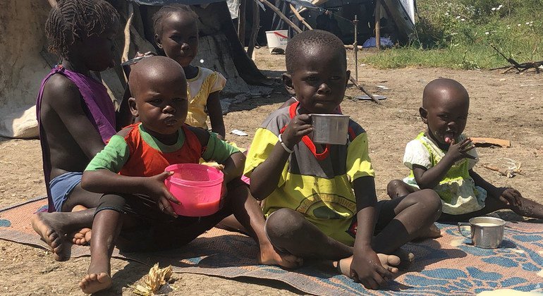 Children eat porridge their mother cooked with the food she received at a World Food Programme (WFP) distribution site in Pibor, South Sudan.