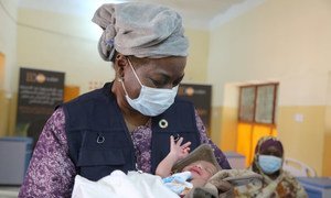 La Directrice exécutive de l'UNFPA, Dr Natalia Kanem, tient dans ses bras un nouveau-né dans une maternité au Soudan.