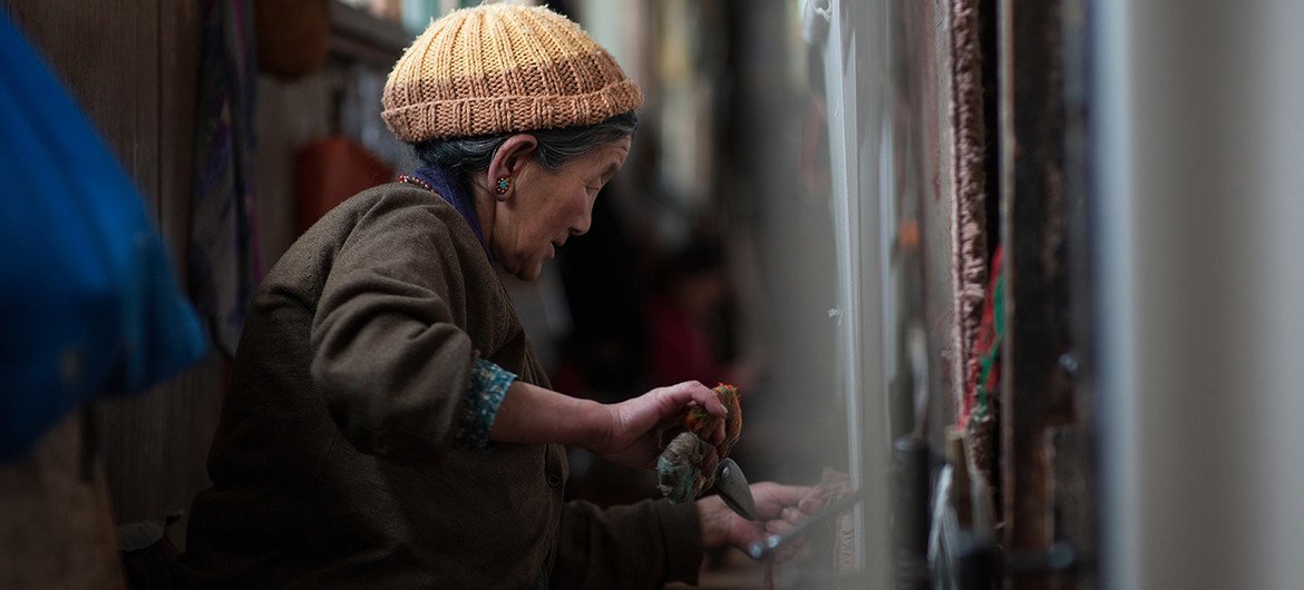 一名移民至印度锡金邦的西藏妇女正在制作织毯。（资料图片）
