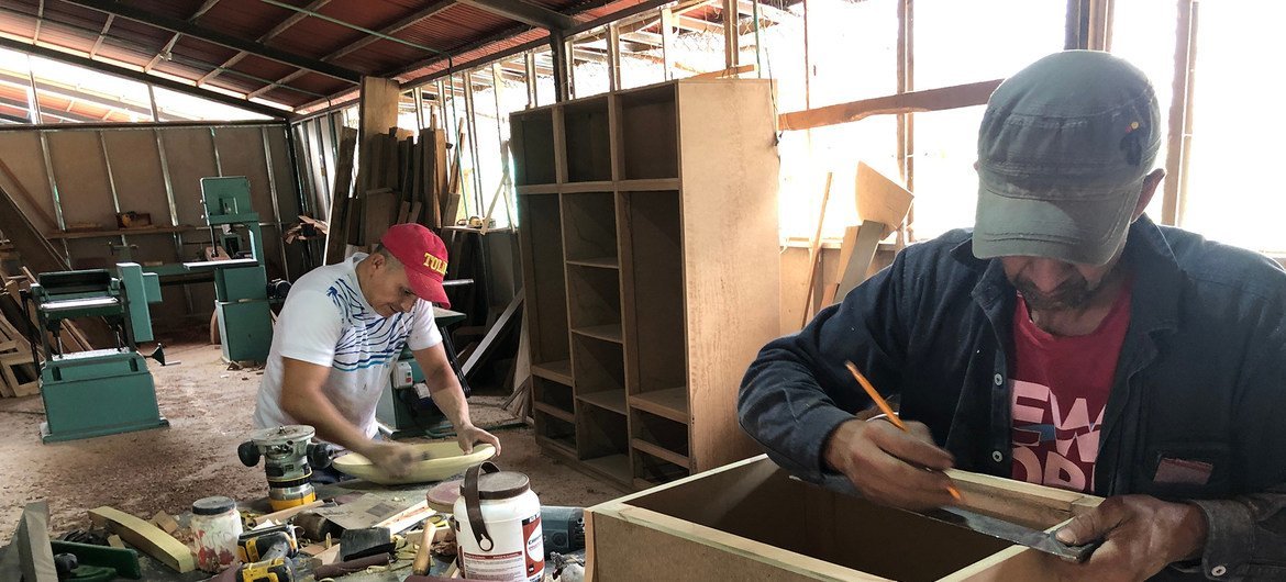 Antiguos combatientes de las FARC trabajan como carpinteros.