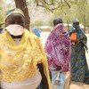Женщины, стоящие в очереди за продовольственными пайками в Камеруне,  соблюдают социальную дистанцию с тем, чтобы не заразиться коронавирусом