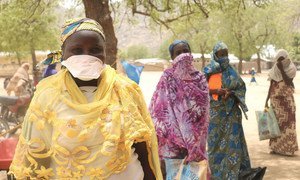 النساء الواقفات في الطابور للحصول على حصص غذائية في الكاميرون، يمارسن التباعد الجسدي للمساعدة في مكافحة انتشار كوفيد-19. 